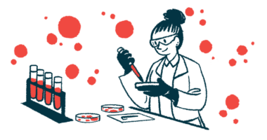 A researcher works with a dropper and petri dishes in a laboratory, with a rack of filled test tubes on the counter nearby.