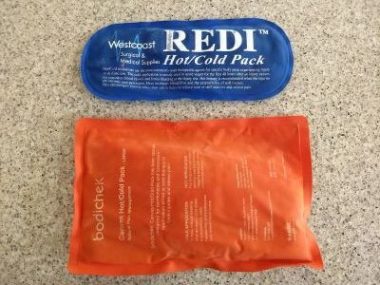 A large orange ice pack and a smaller blue ice pack lie next to each other on a counter.